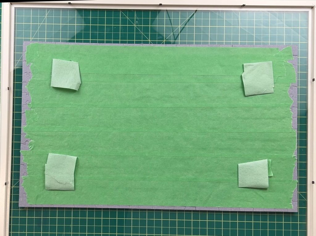 Taping the back of a puzzle to frame it
